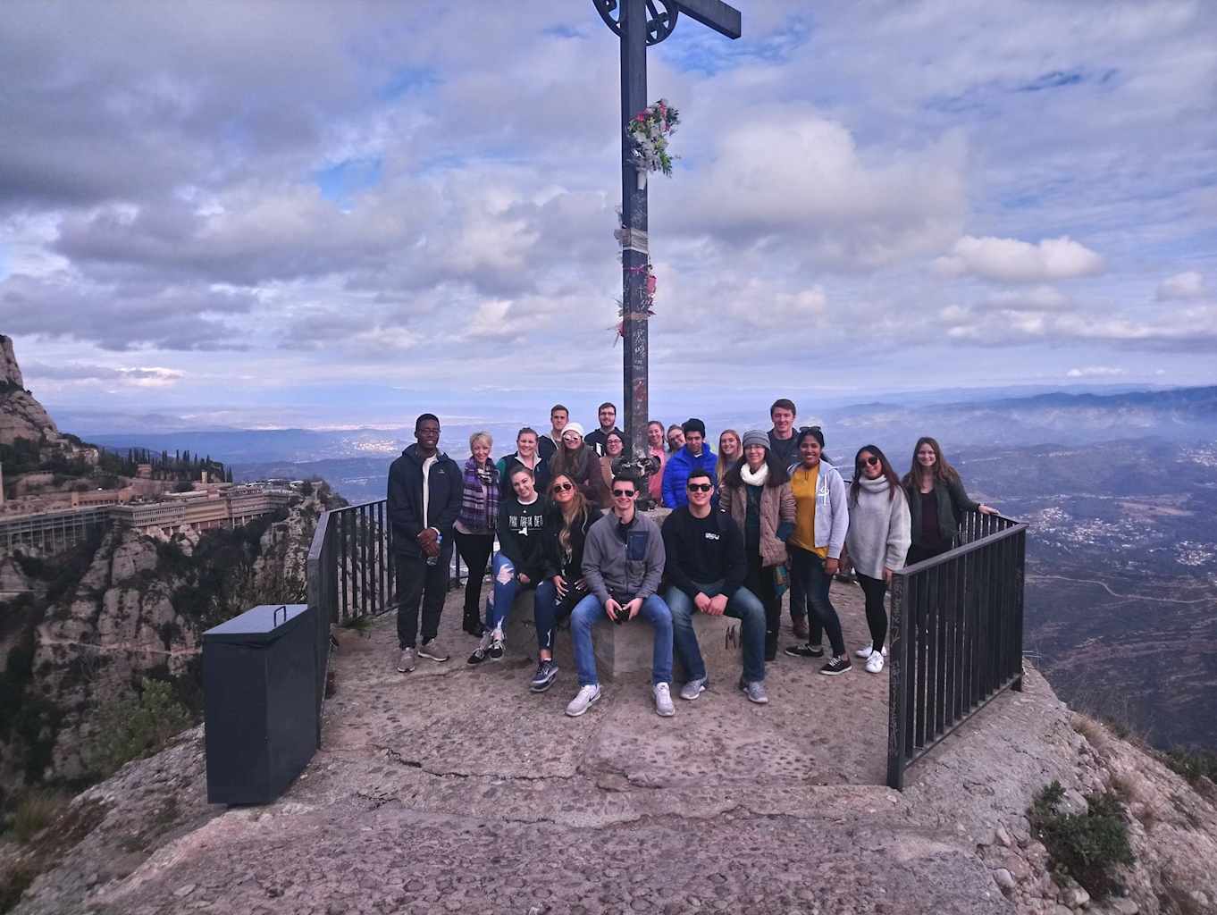 Group posing in front of pole.