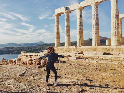 A student dancing near pillars on the Acropolis in Greece.