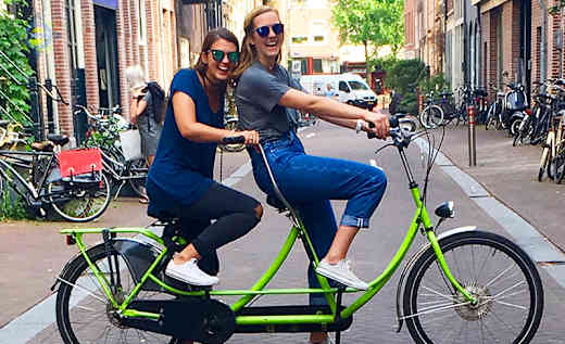 Two students riding a bike together in Dublin, Ireland.