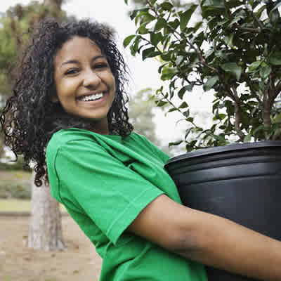 A woman holding a plant.