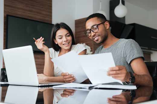 Young man and woman review financial documents.