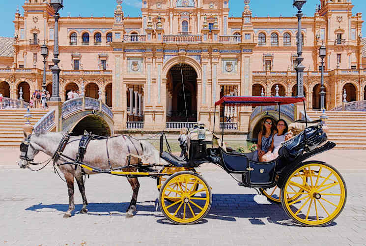 Two students on a horse carriage in Spain.