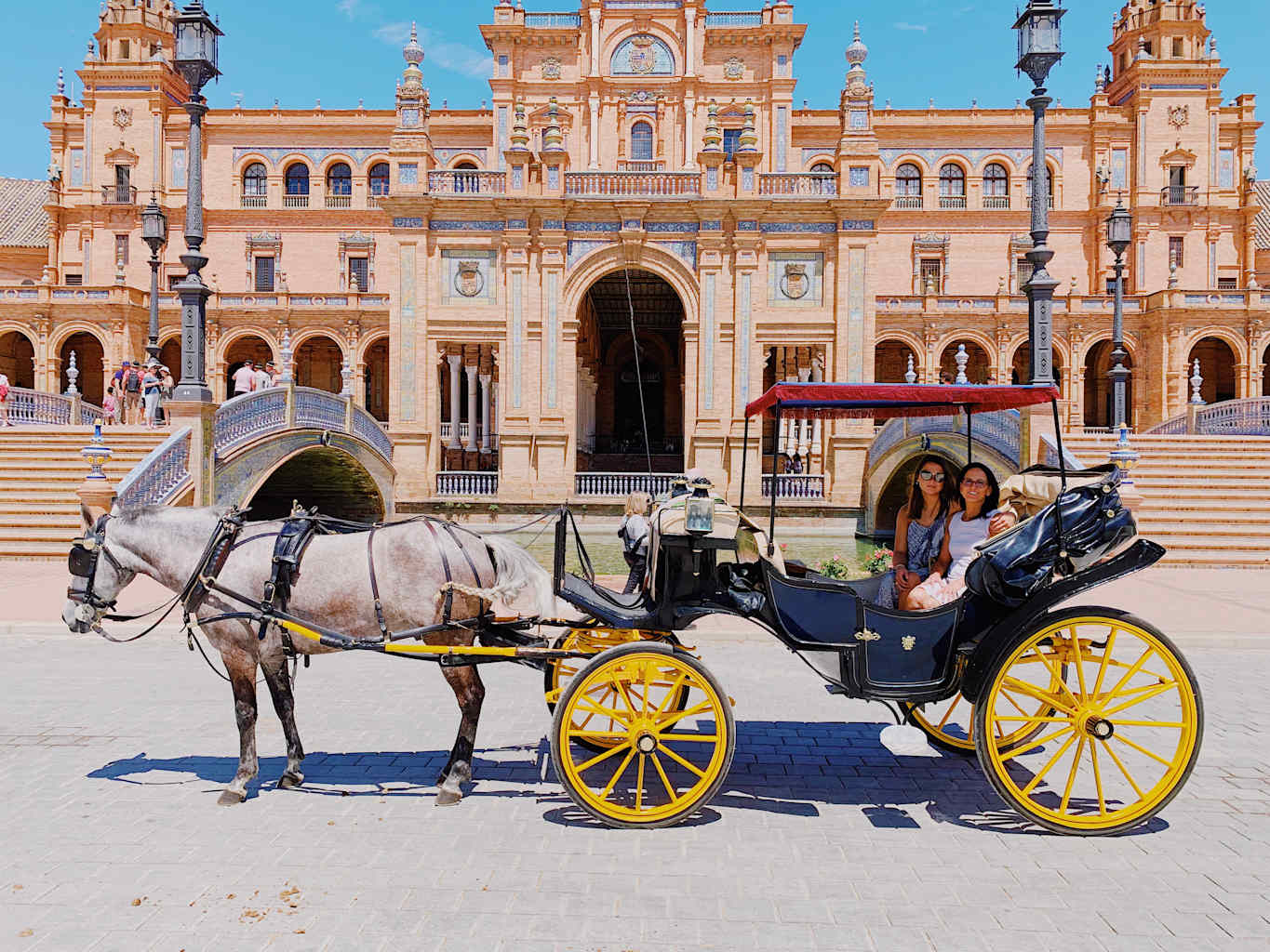 Two students on a horse carriage in Spain.