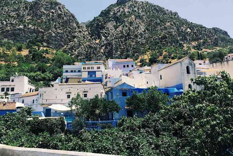 White buildings nestled alongside trees on a mountain in Spain.
