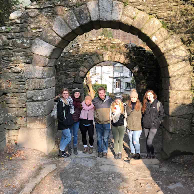 Group of people smiling under arch.