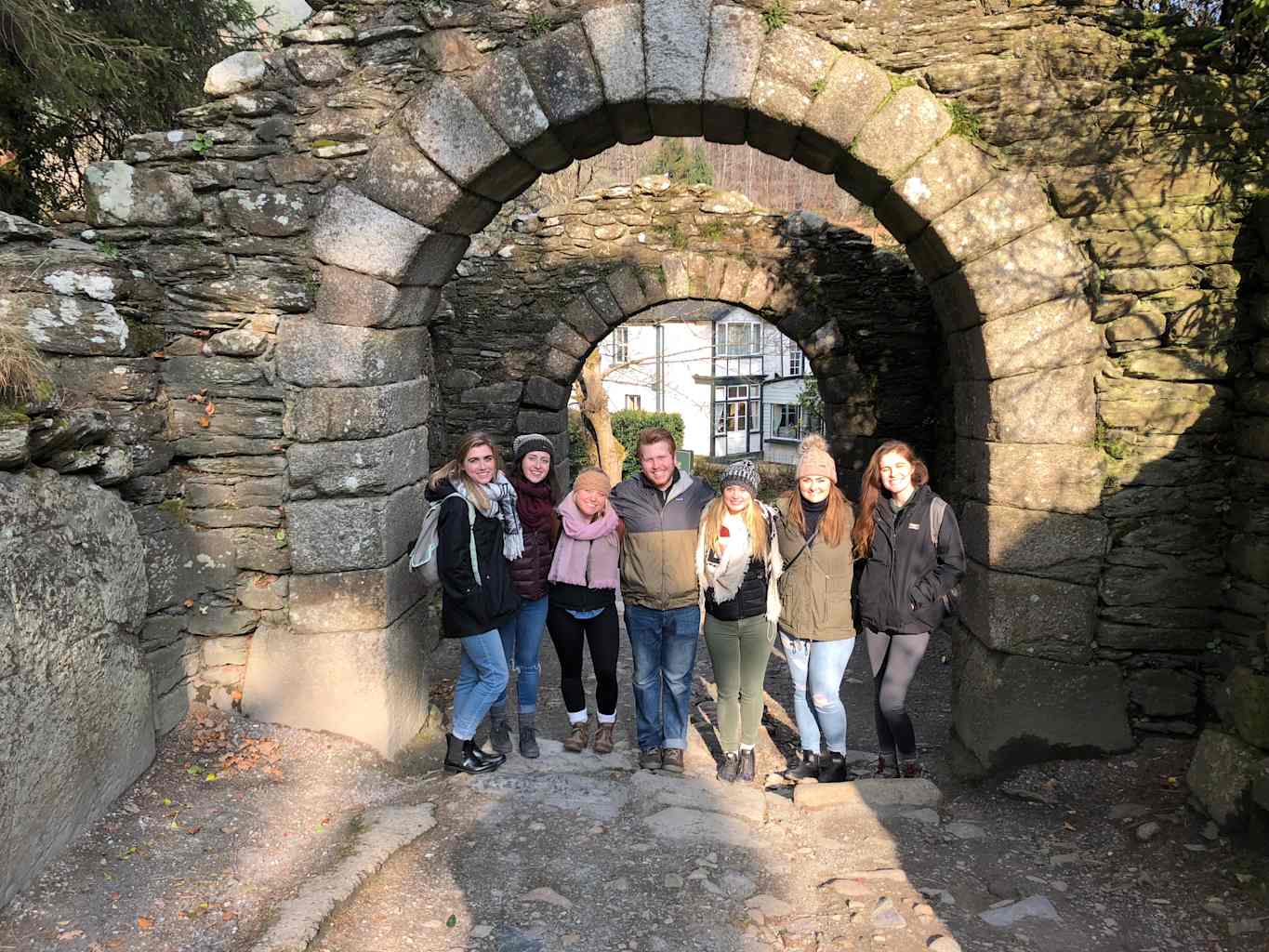 Group of people smiling under arch.