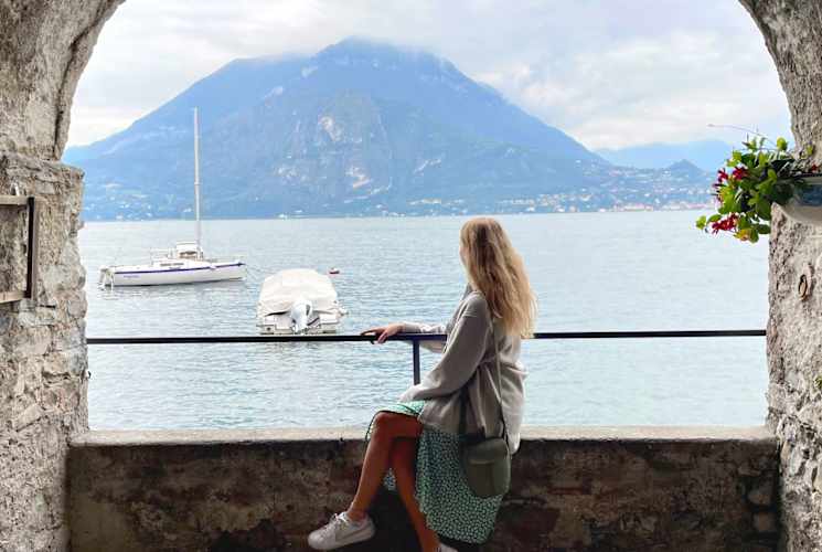 Girl sitting on edge under arch.