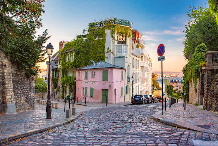 A street in Paris with a pink building.