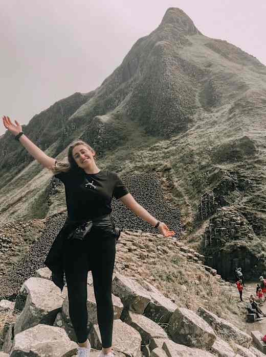 A student standing on rocks in Maynooth, Ireland.