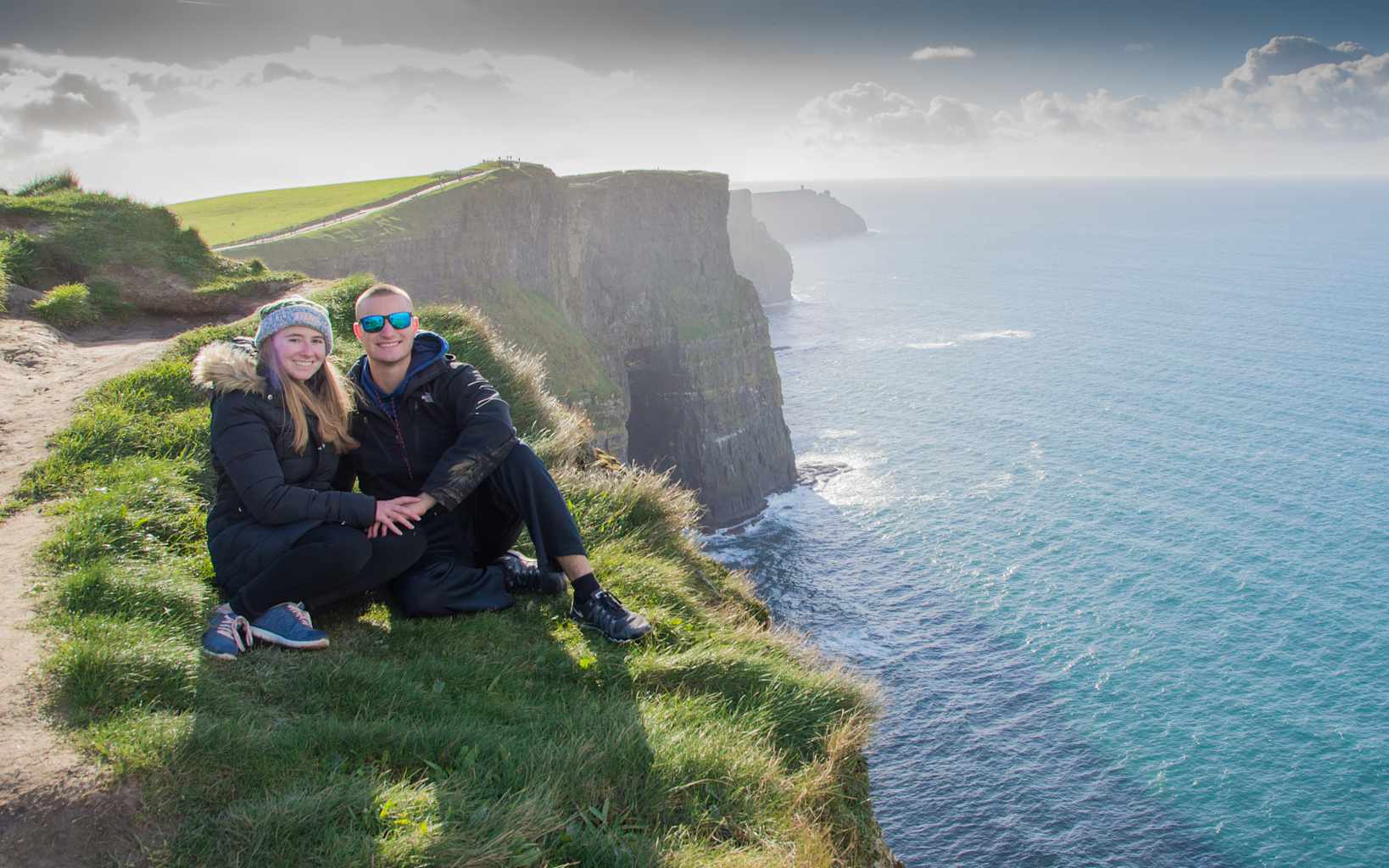 Two students sitting on the cliffs of Moher in Ireland.