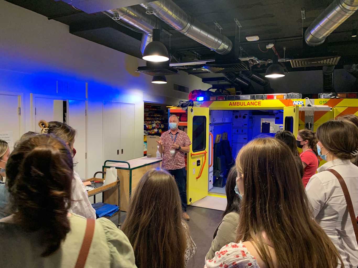 A group of students listening to an instructor during a demonstration.
